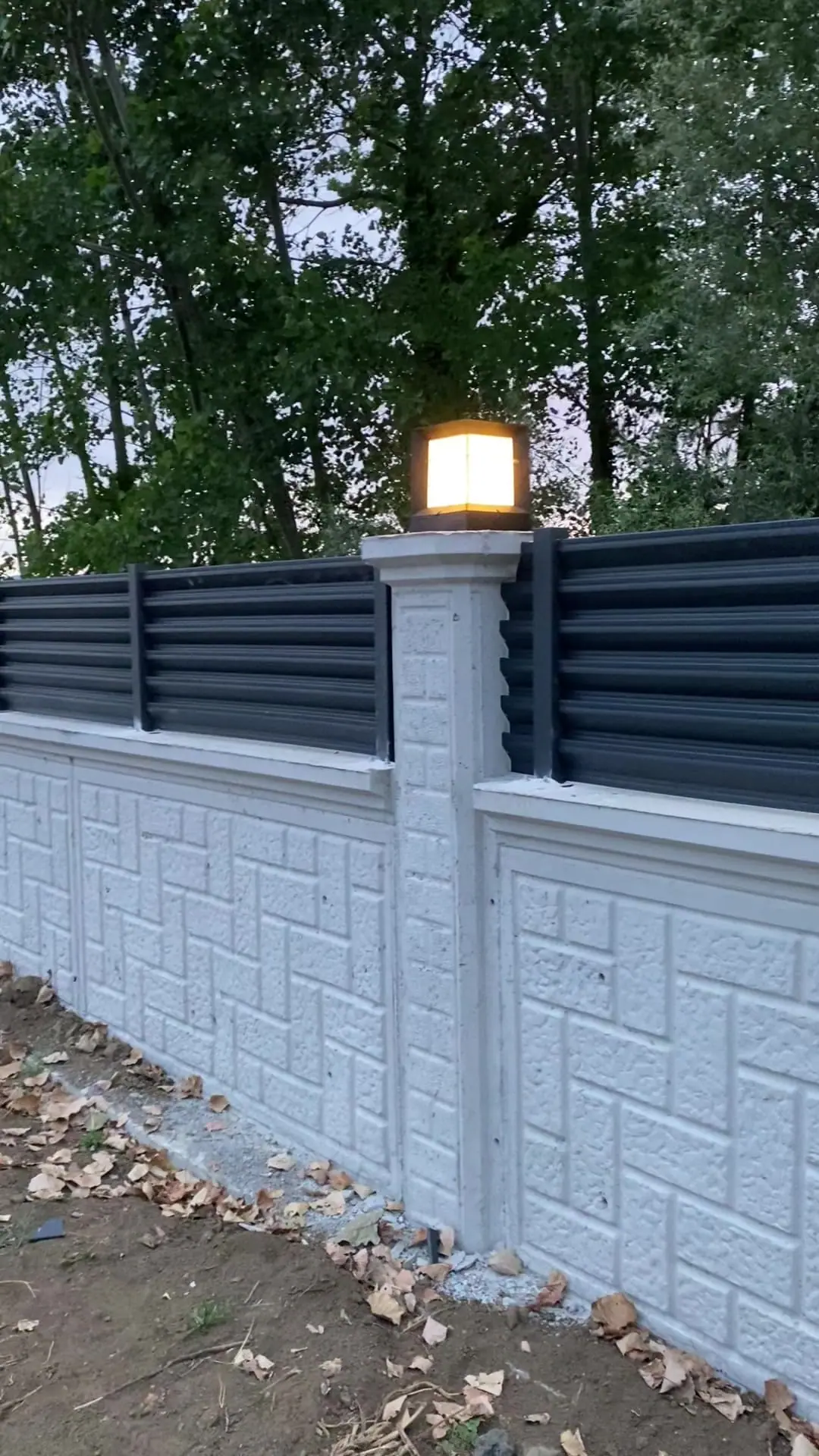 Beyaz bahçe duvarı üstünde antrasit panjur çit
