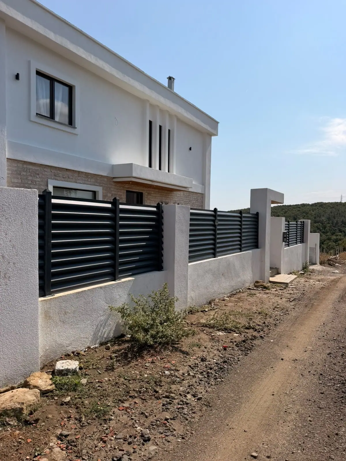 Beyaz villa çevresinde antrasit panjur çit